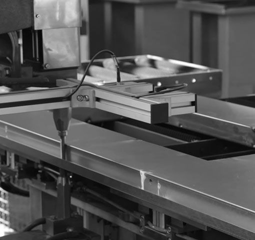Eine Maschine arbeitet an einem Tisch in einer Fabrik, um Produktionsprozesse effizient zu gestalten.